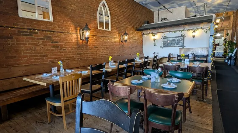 Wooden tables along the brick wall of the dining room