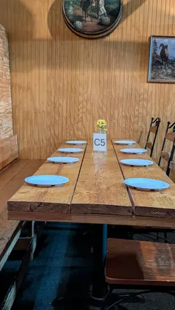 A long wooden table set with blue plates