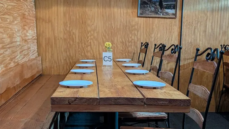 A long table set for a group in the wood-paneled room