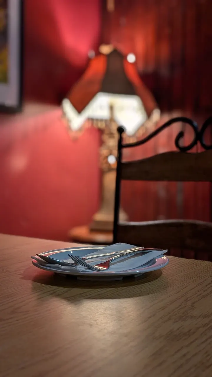 A table lamp glowing against a red wall