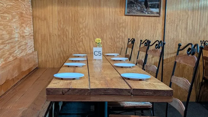 A long table set for a group in the wood-paneled room