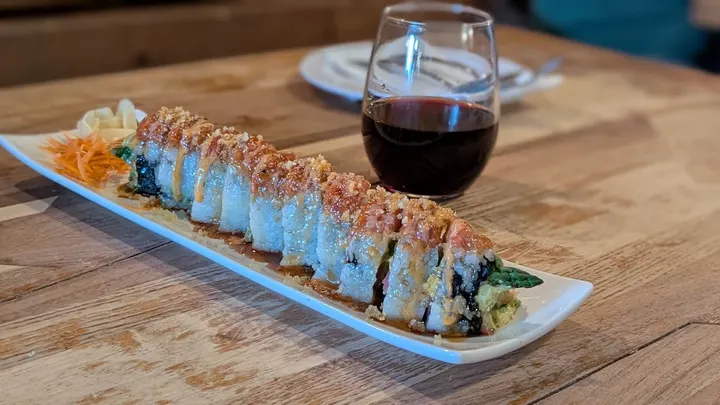A sushi roll and a glass of red wine