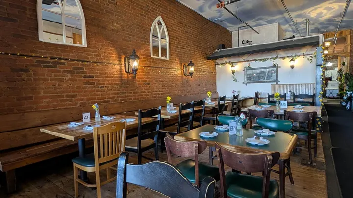 The brick-walled dining room with arched windows